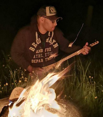 Damon playing his three string dulcimer by a camp fire